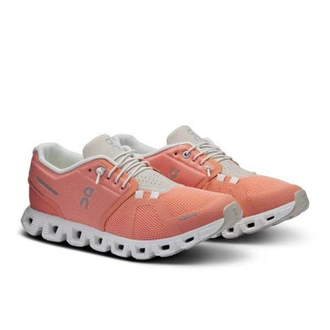 נעלי On Cloud 5 Flamingo/Pearl 59.97765 של On Cloud הן נעלי ספורט בוורוד קורל עם סוליות ושרוכים לבנים, בעלות בד רשת וסוליות מרופדות ומפולחות המיועדות לנוחות ותמיכה מיטבית.