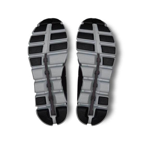 התמונה מציגה את הסוליות של זוג נעלי On Cloud 5 Push M Rock/Black 69.97739, עם עיצוב מפולח הכולל חלקים אפור כהה ואפור בהיר על רקע לבן.